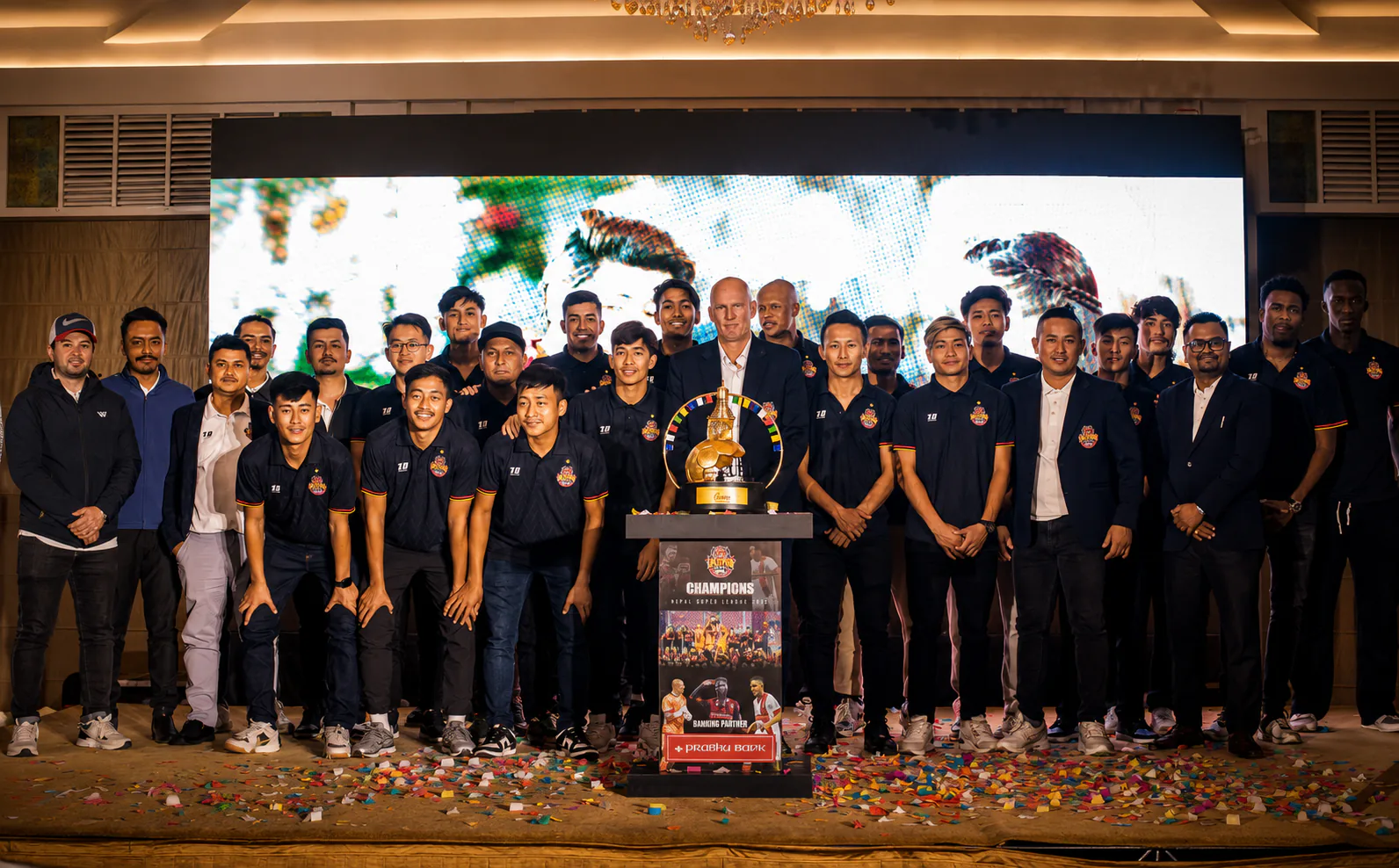 Lalitpur City FC players and staff gathered around the championship trophy
